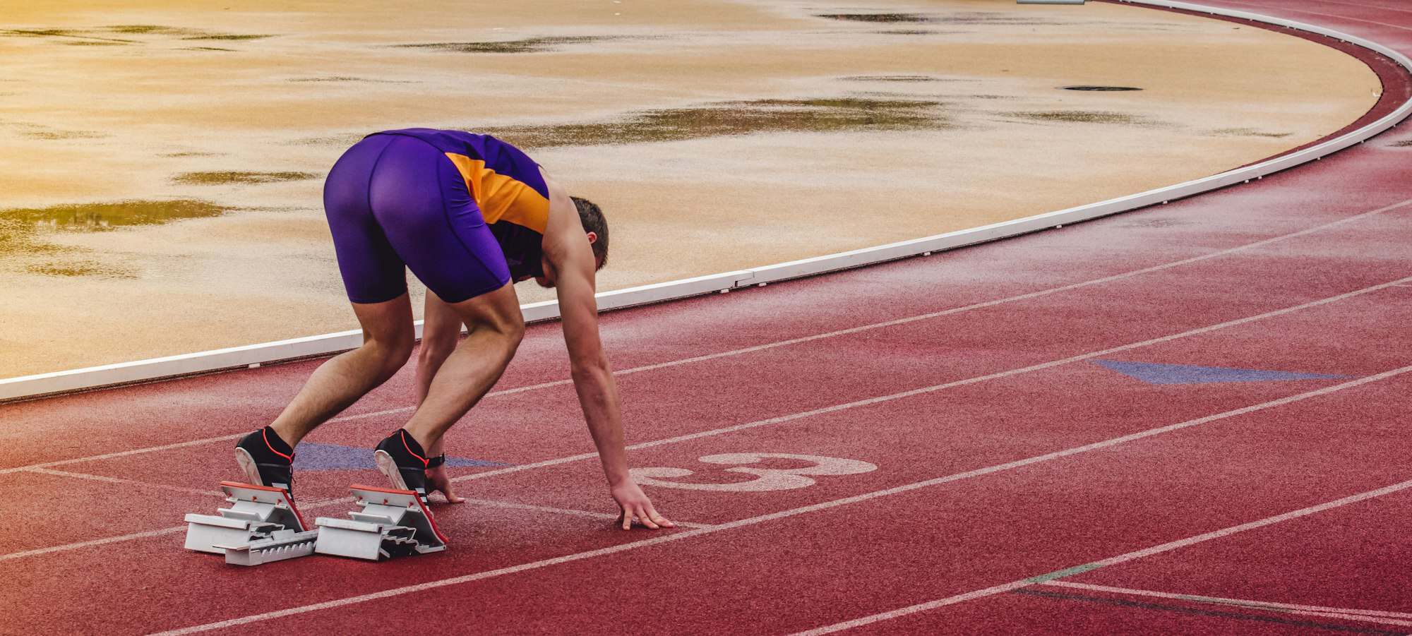 An athlete at the start line of a running track