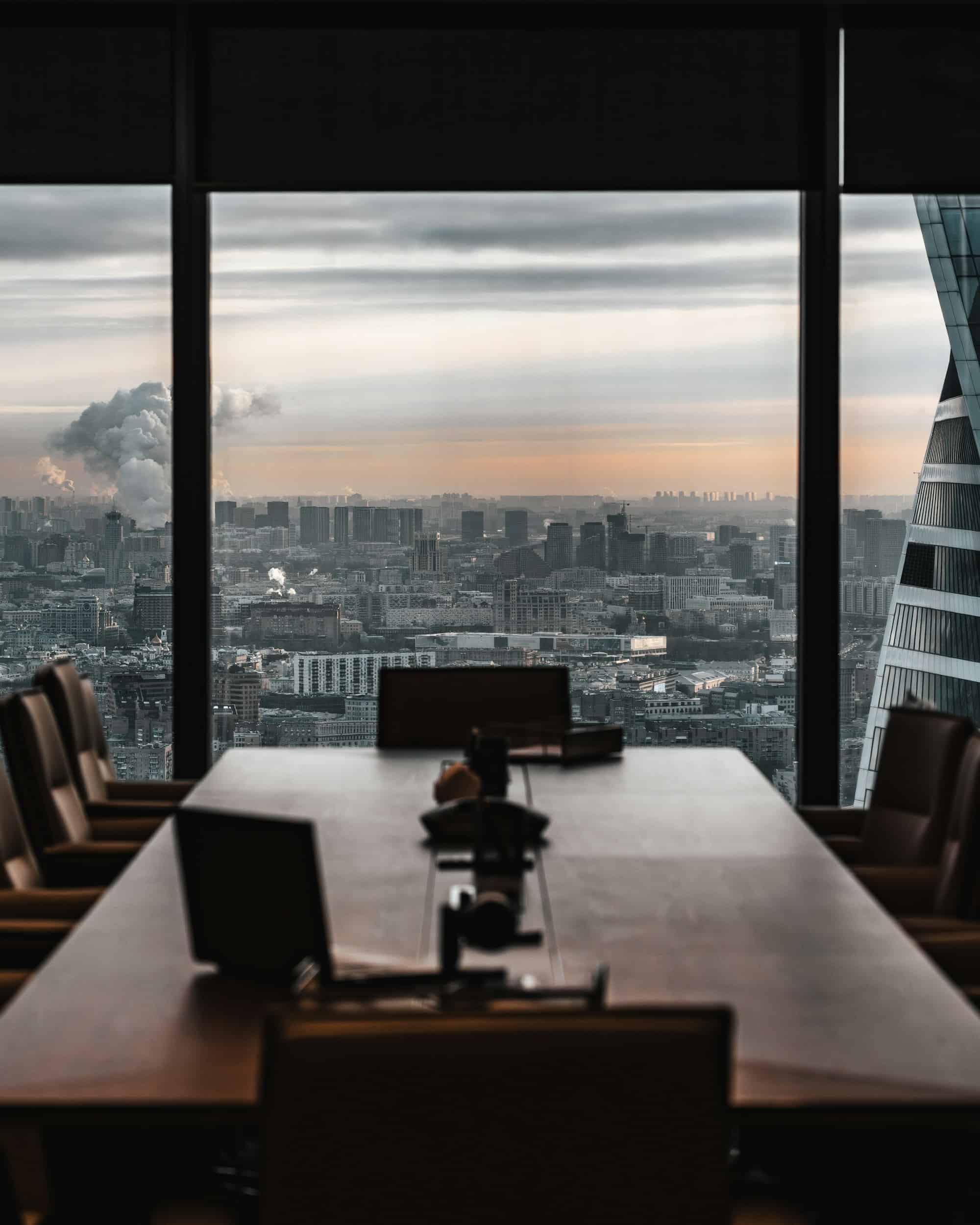 A boardroom overlooking a city skyline at dusk
