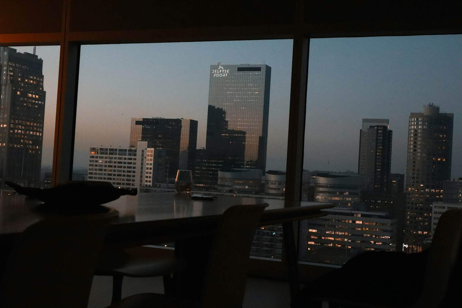 High-rise office window overlooking a city skyline at dusk