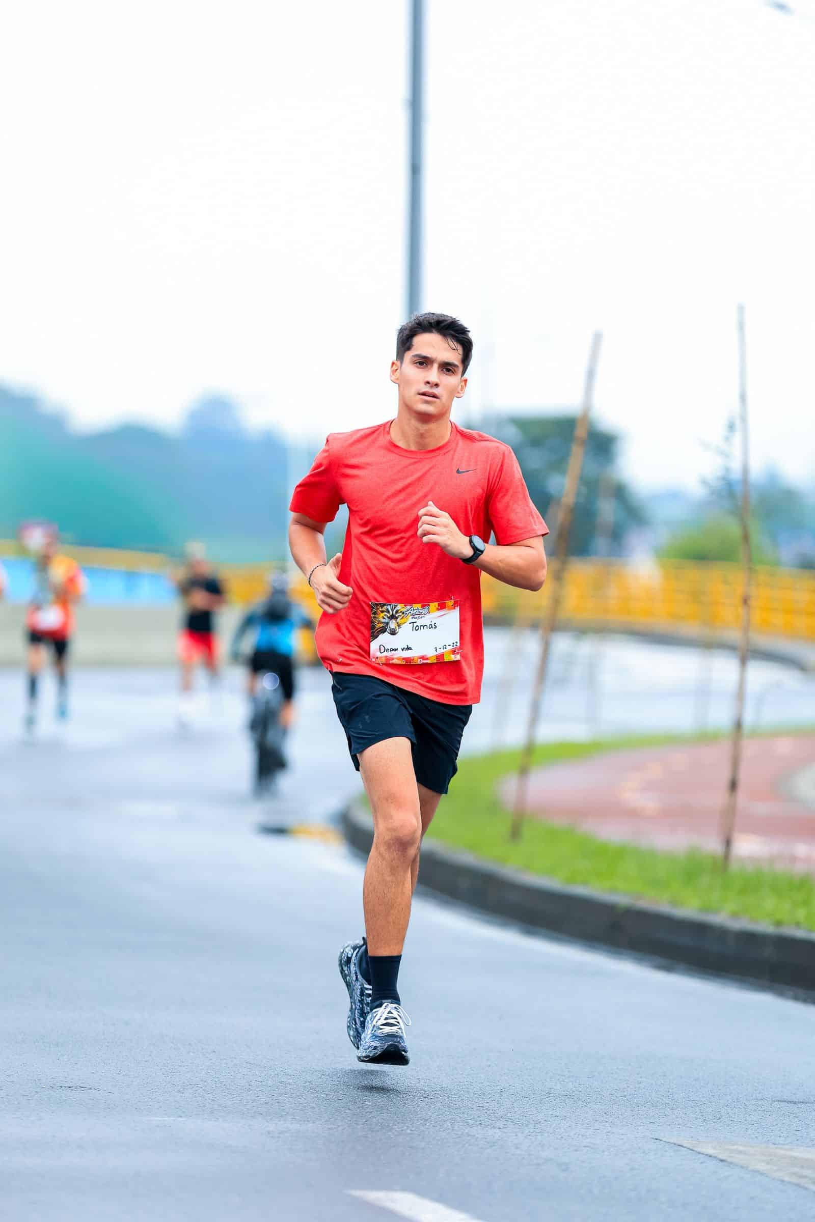 Runner in a red shirt and race bib during a road race