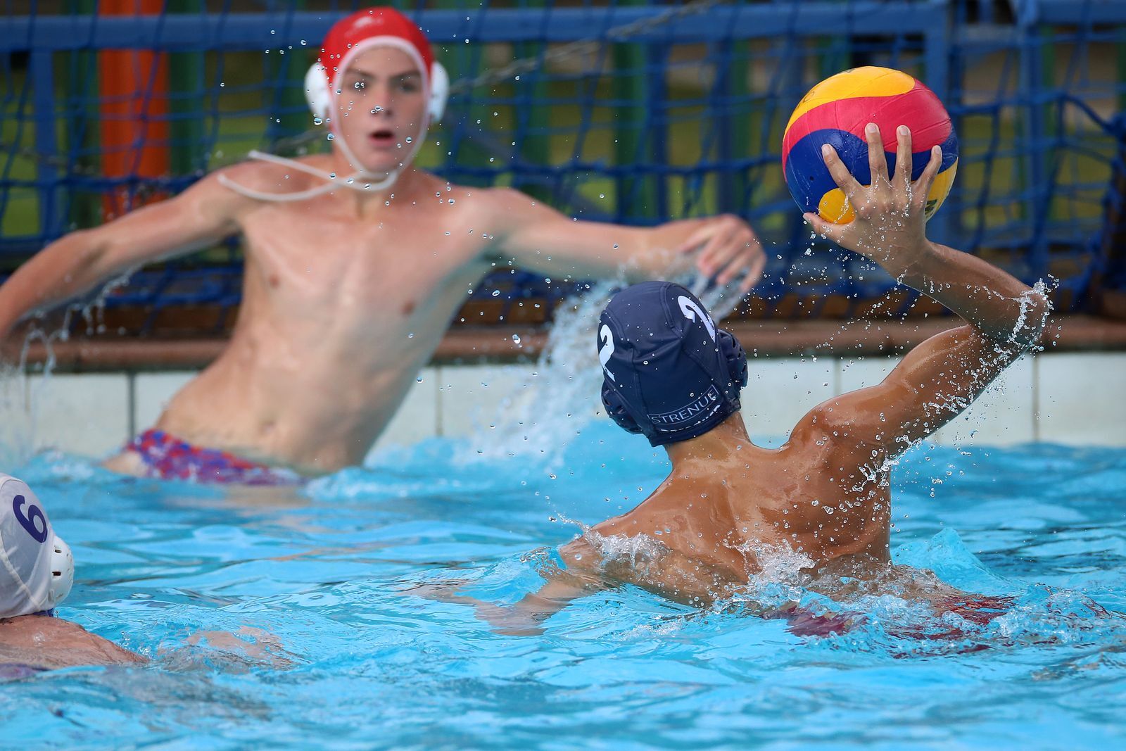 Water polo players competing for the ball in the pool